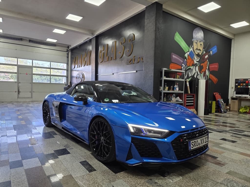 Audi R8 V10 performance Spyder in Ara-Blau, Frontansicht schräg in einer Studiohalle